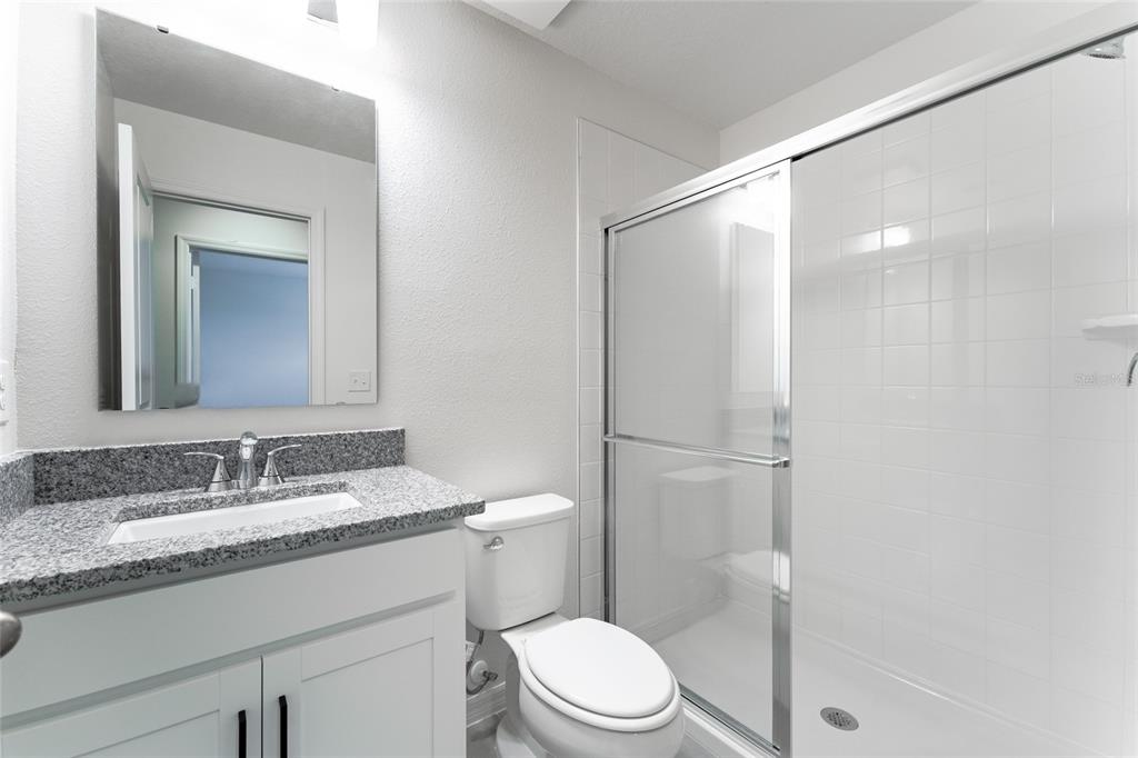 2770 Raindrop Run Street Clermont, FL 34714 - Photo 16 of 28 a bathroom with a granite countertop sink toilet and shower