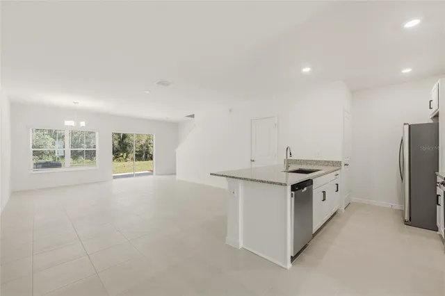 a kitchen with granite countertop a sink stove and refrigerator