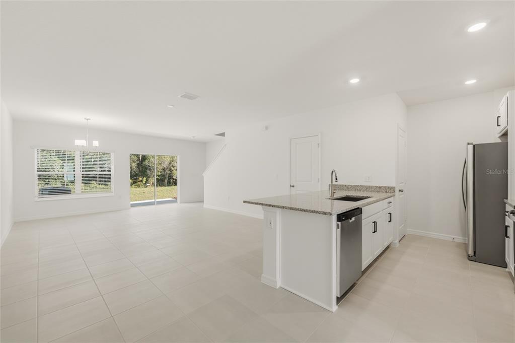 2770 Raindrop Run Street Clermont, FL 34714 - Photo 2 of 28 a kitchen with granite countertop a sink stove and refrigerator