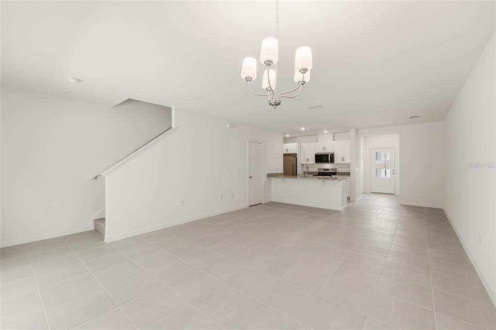 2770 Raindrop Run Street Clermont, FL 34714 - Photo 9 of 28 an empty room with a kitchen and chandelier