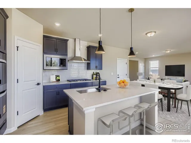 a kitchen with a sink a counter top space and living room view