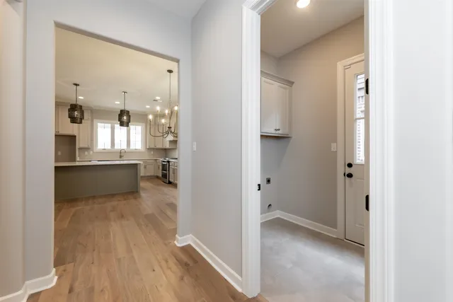 a view of a hallway with wooden floor and a living room