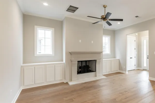 a view of an empty room with window and fire place