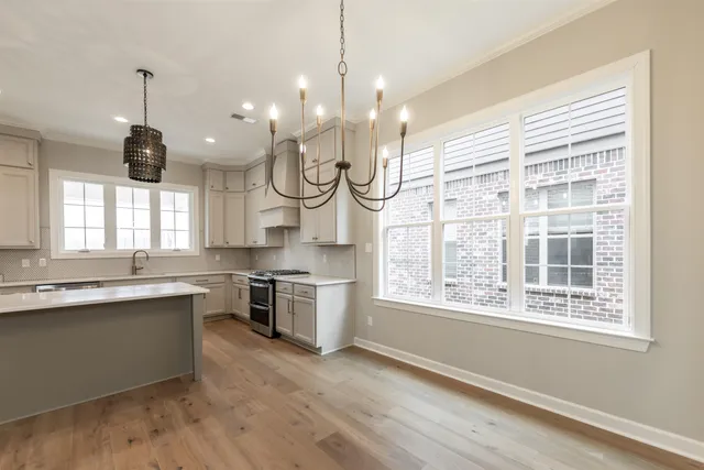 a large kitchen with a large window and stainless steel appliances