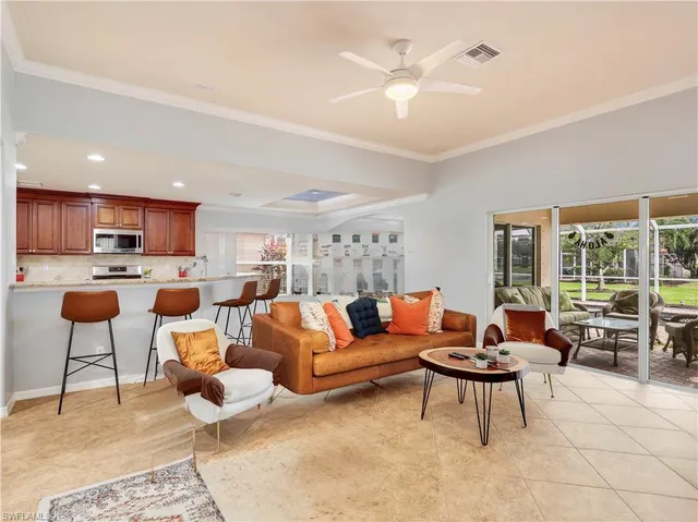 a living room with furniture kitchen view and a large window