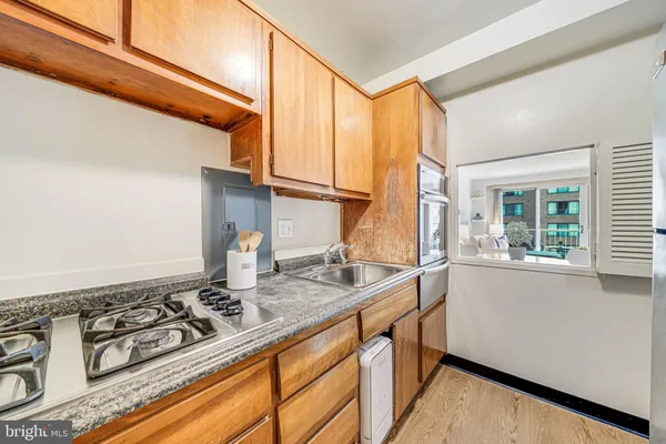 a kitchen with stove a sink and a window