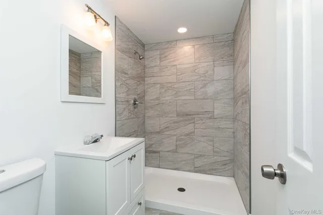 a bathroom with a shower a mirror and a sink