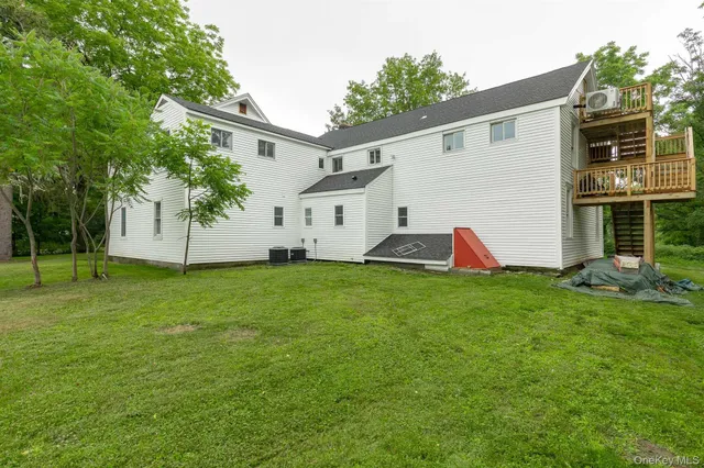 a view of a backyard with plants and a large tree