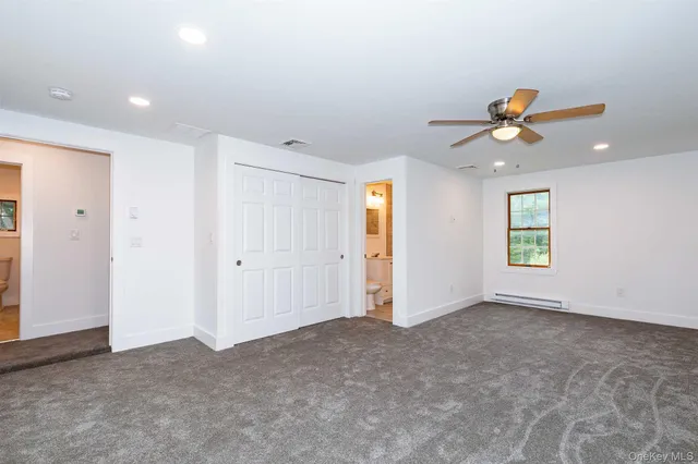 an empty room with closet and a ceiling fan