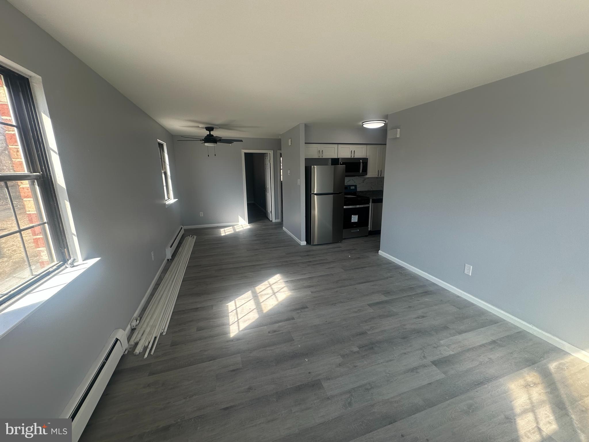 18-20 Thomas Road, Unit 18 Aston, PA 19014 - Photo 3 of 12 an empty room with wooden floor and windows