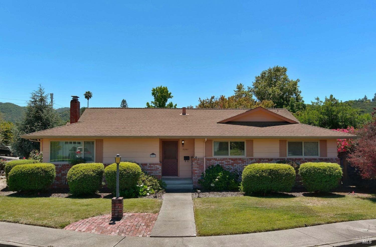 a front view of a house with a garden and plants