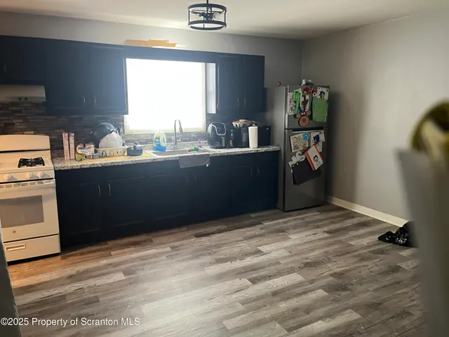 an empty room with wooden floor and entrance