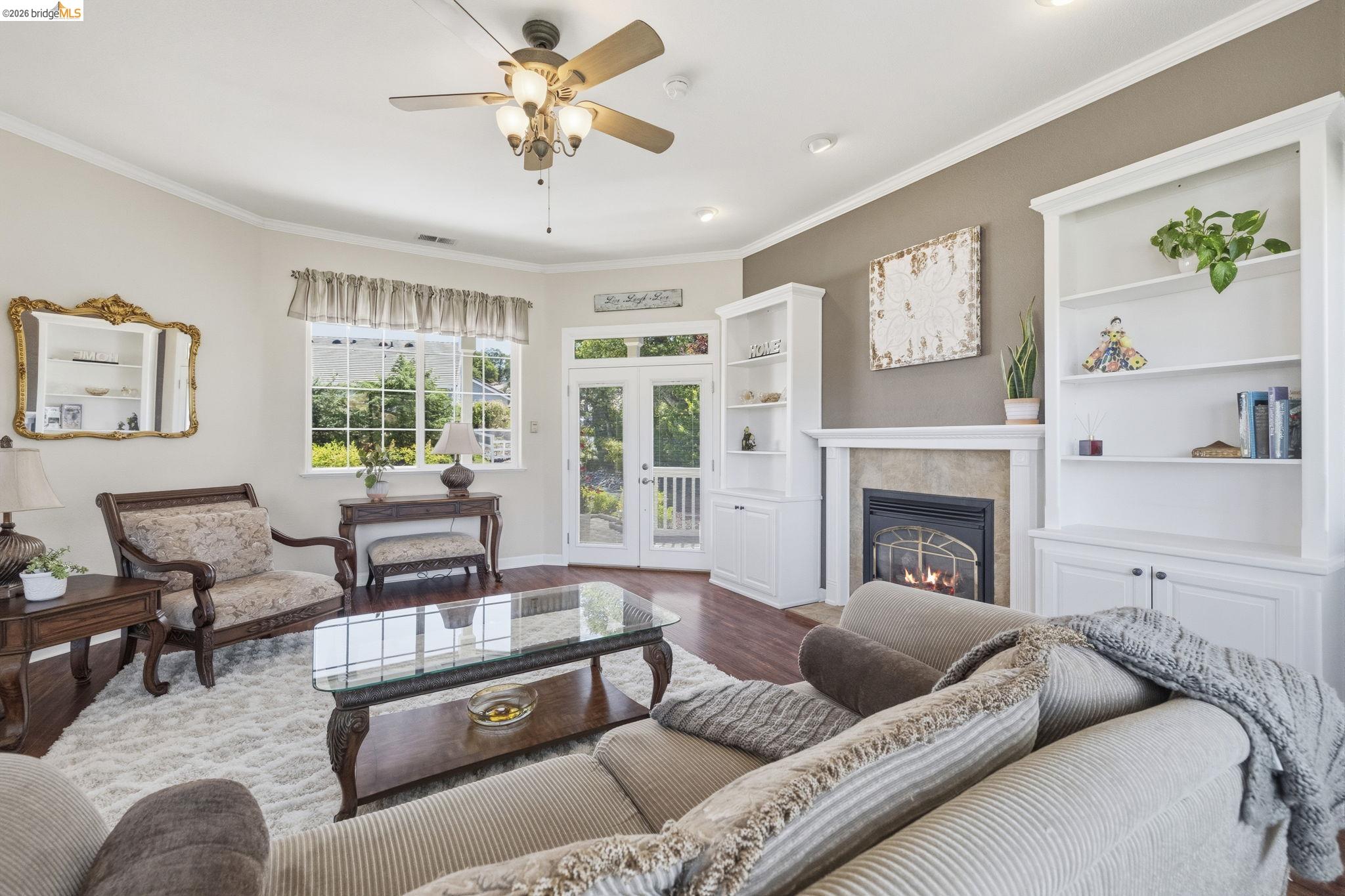 6242 Bluff View Road Copperopolis, CA 95228 - Photo 10 of 59 Living area featuring wood-finish flooring, a fireplace with a stone surround, and built-in white cabinetry