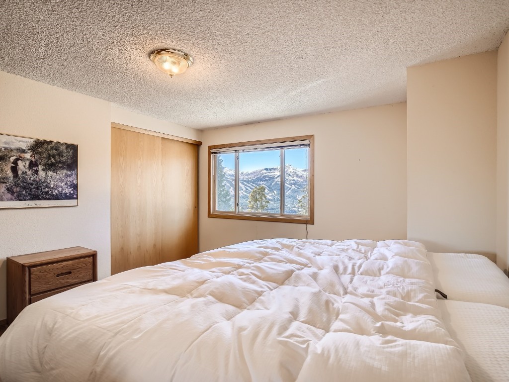 52 Club House Road, Unit 54 Breckenridge, CO 80424 - Photo 15 of 28 a bedroom with a large bed and a window