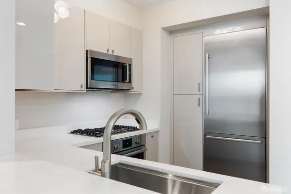 a kitchen with stainless steel appliances a stove a sink and a microwave
