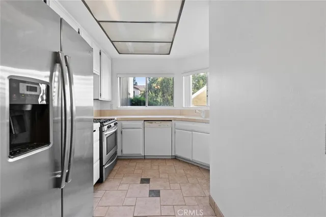 a sink with a window and cabinets
