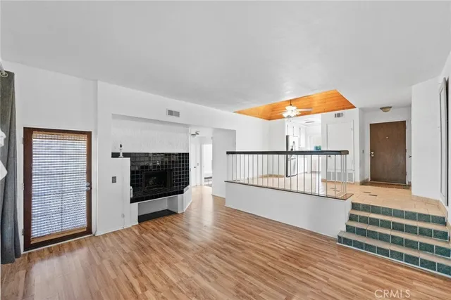 a view of empty room with wooden floor and fireplace
