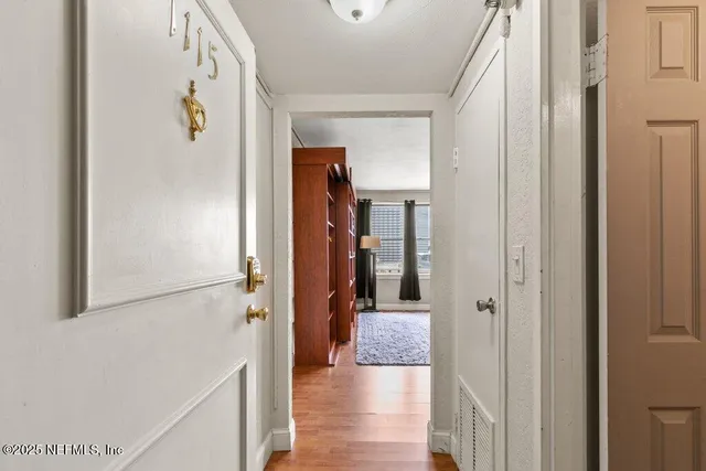 a view of a hallway with wooden floor