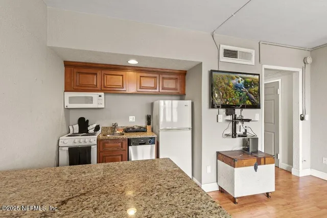 a living room with stainless steel appliances kitchen island a stove a refrigerator cabinets and living room view