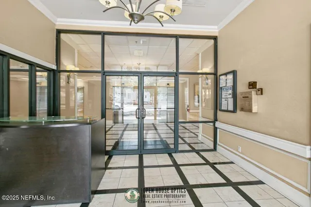 a view of a hallway with wooden floor and a chandelier