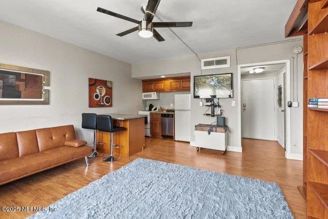 a living room with furniture and a wooden floor