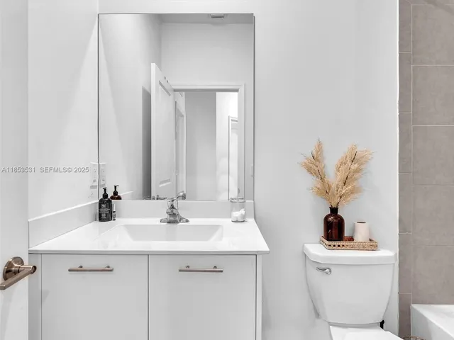 a bedroom with a bed and a flat tv screen on dresser