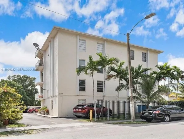 a palm tree sitting in front of a house