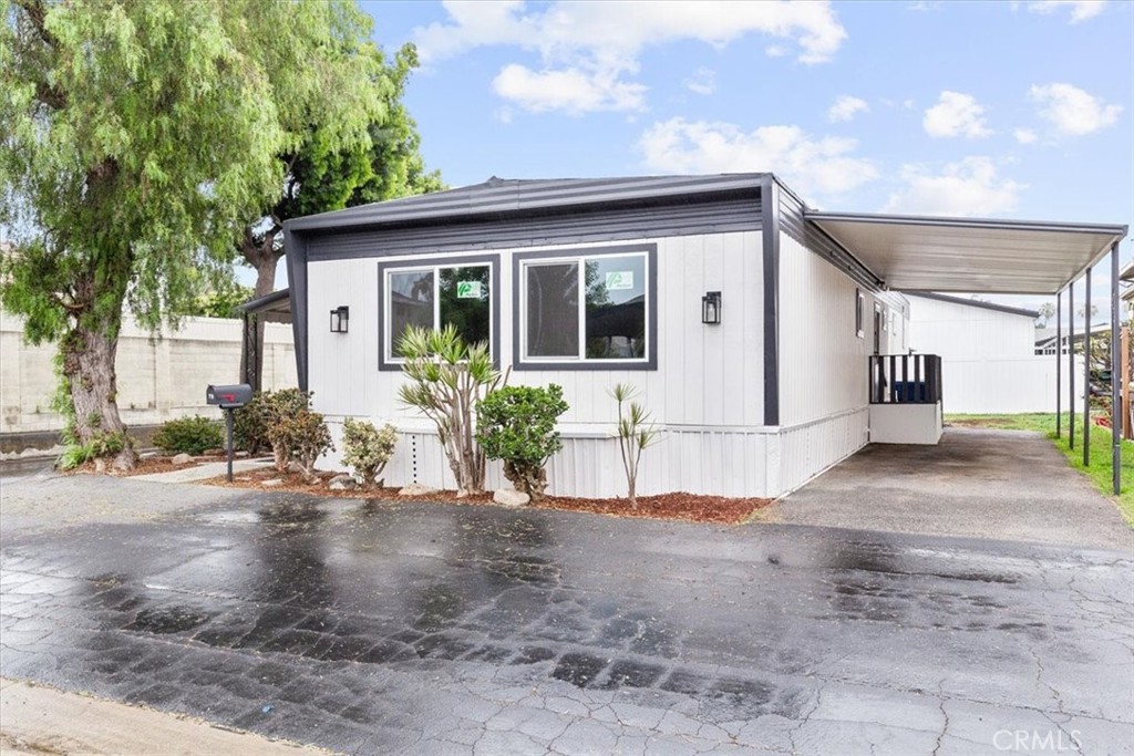 a front view of a house with a yard and potted plants