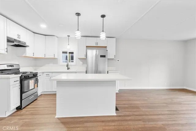 a kitchen with kitchen island a sink stainless steel appliances and cabinets
