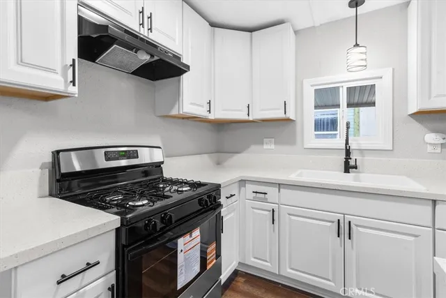 a kitchen with white cabinets and appliances