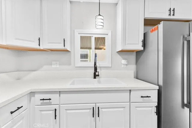 a kitchen with white cabinets and a refrigerator