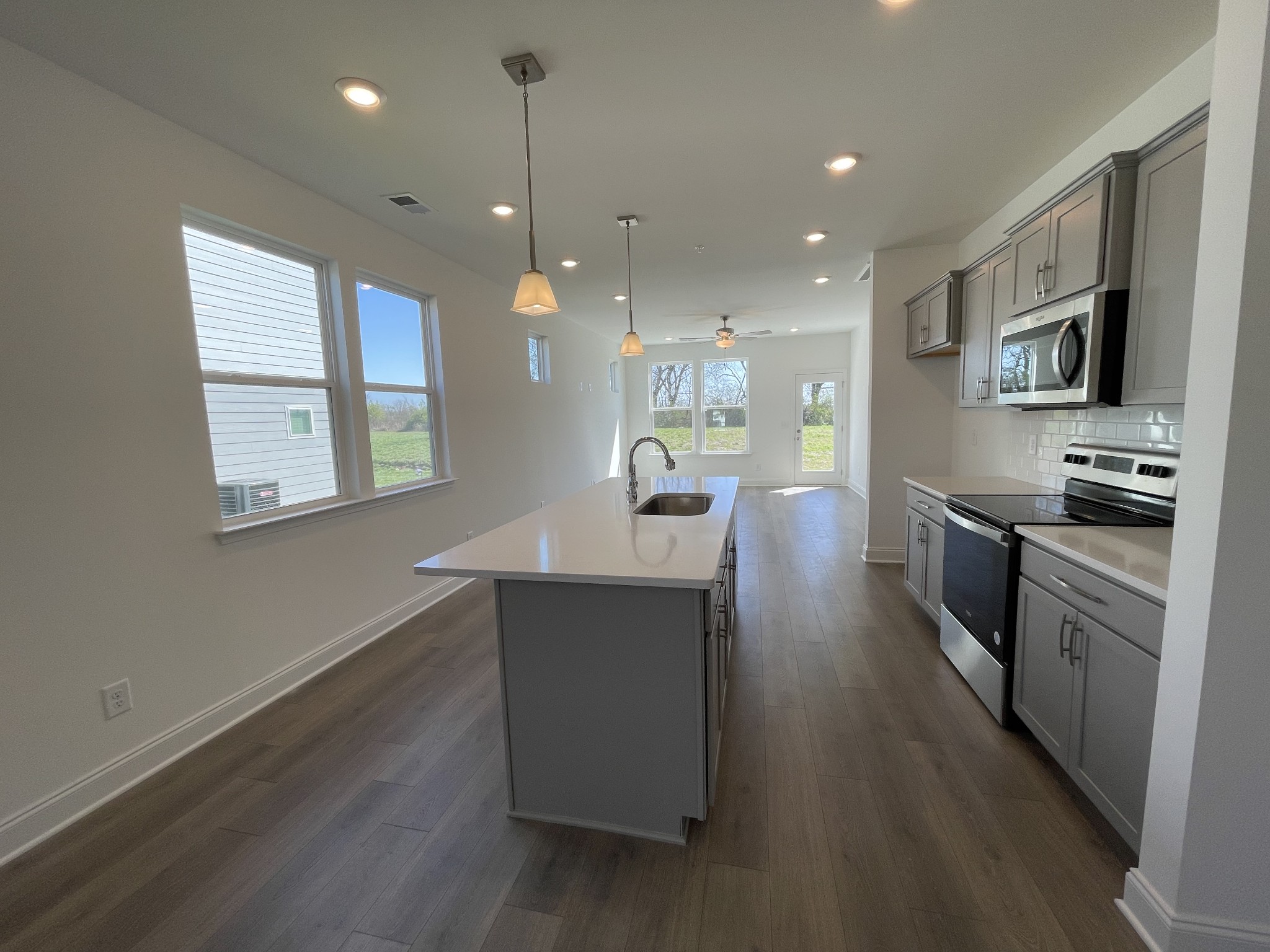 1156 June Wilde Ridge Spring Hill, TN 37174 - Photo 4 of 20 a kitchen with counter top space a sink wooden floor and stainless steel appliances