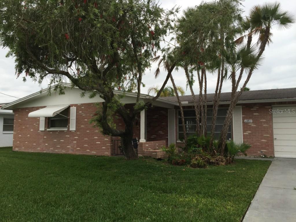 12821 1st Isle Port Richey, FL 34667 - Photo 1 of 1 a front view of a house with a garden
