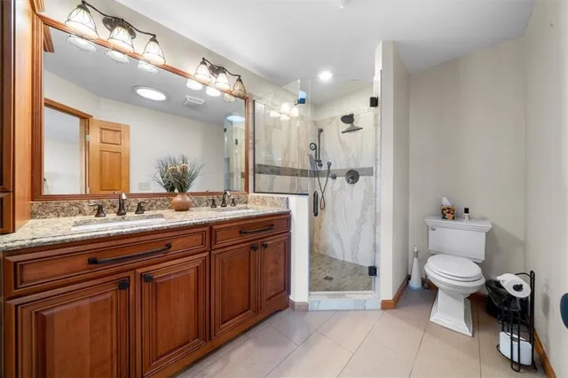 a spacious bathroom with a granite countertop sink mirror and toilet