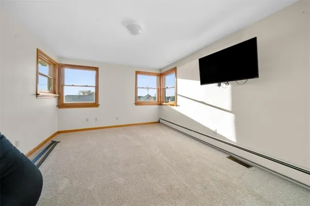 a view of an empty room with a flat screen tv and a window