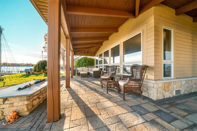 a view of a patio with lawn chairs floor to ceiling window next to a yard