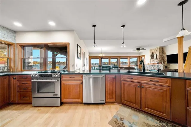 a large kitchen with stainless steel appliances granite countertop a stove and a sink