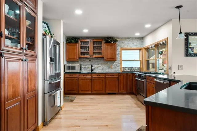 a kitchen with stainless steel appliances granite countertop a refrigerator and a sink