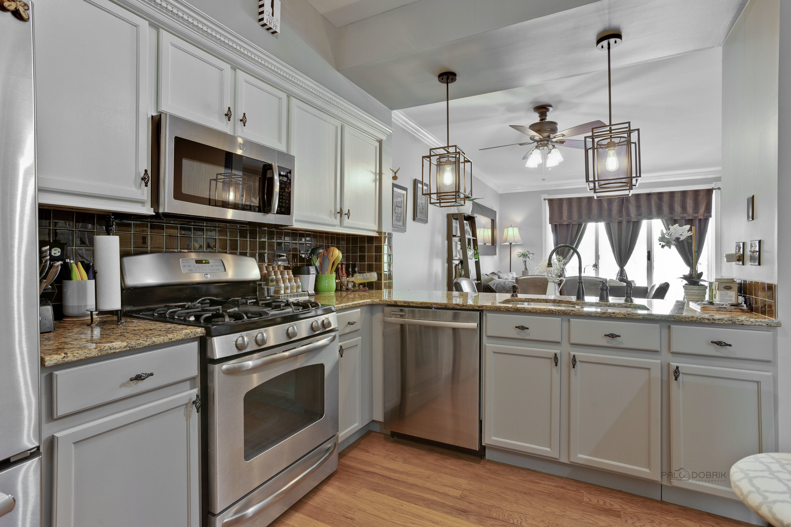 17898 Braewick Road Gurnee, IL 60031 - Photo 4 of 25 a kitchen with stainless steel appliances granite countertop white cabinets a sink a stove a dining table and chairs