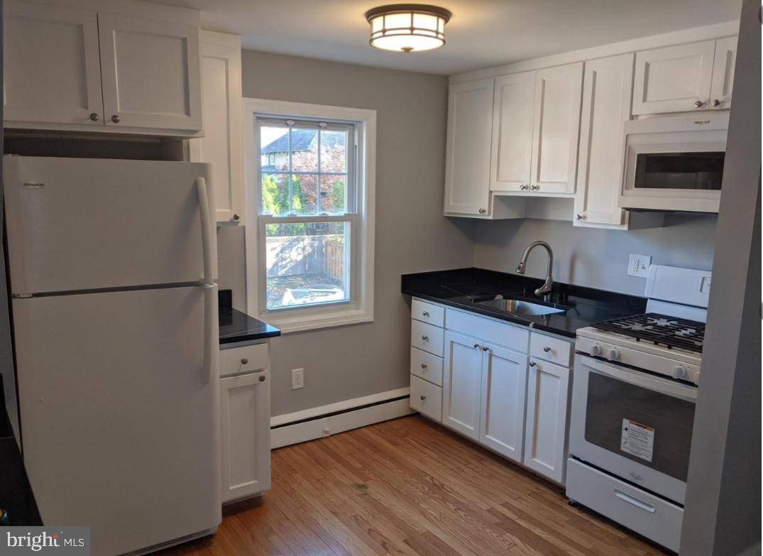 205 North Haddon Avenue Haddonfield, NJ 08033 - Photo 3 of 16 a kitchen with granite countertop white cabinets stainless steel appliances and sink
