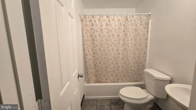 a white toilet sitting next to a shower curtain