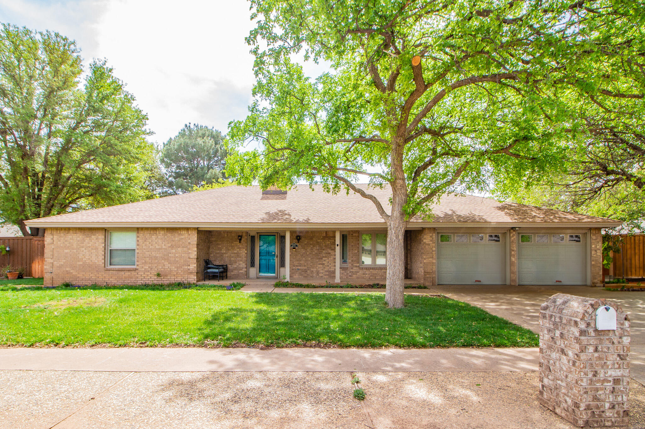 4213 88th Place Lubbock, TX 79423 - Photo 1 of 40 a front view of a house with a garden and trees