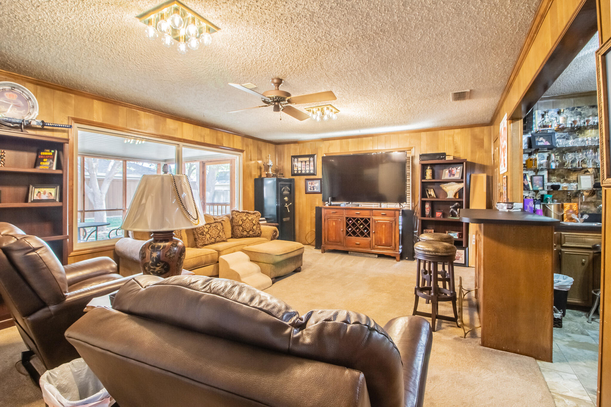 4213 88th Place Lubbock, TX 79423 - Photo 19 of 40 a living room with furniture a large window and a flat screen tv