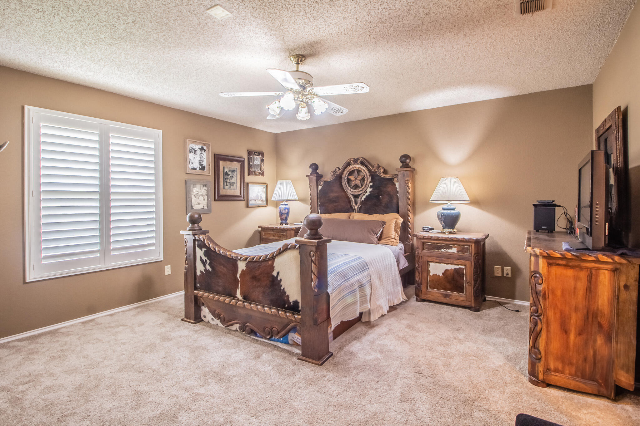 4213 88th Place Lubbock, TX 79423 - Photo 30 of 40 a spacious bedroom with a bed and a chandelier