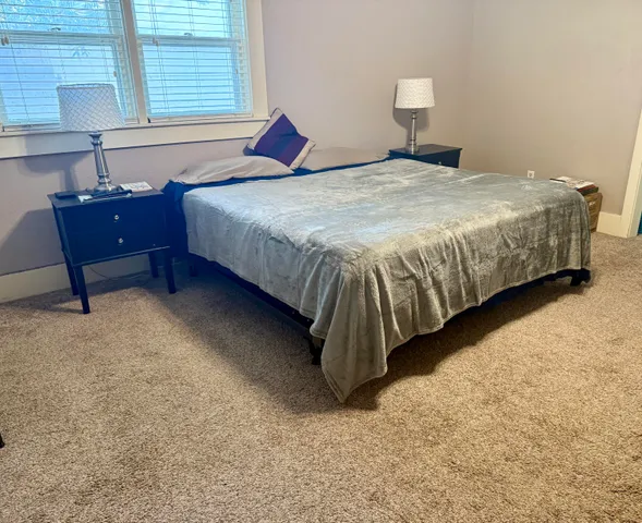 a bedroom with a bed and a lamp on table