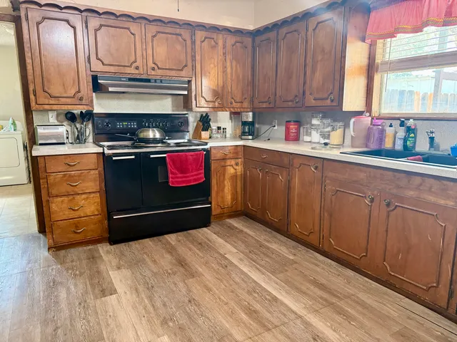 a kitchen with stainless steel appliances granite countertop a refrigerator stove and sink