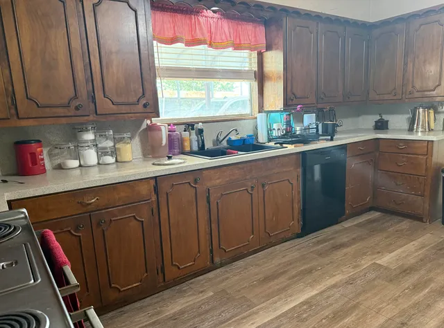 a kitchen with stainless steel appliances granite countertop a sink a stove and cabinets