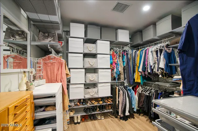 a view of walk in closet with clothes and shoes
