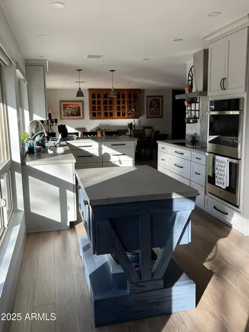 a living room with stainless steel appliances kitchen island granite countertop furniture and a view of kitchen