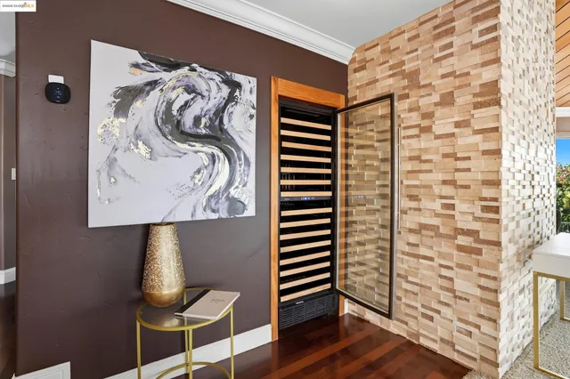 a view of a hallway with wooden floor and a bathroom